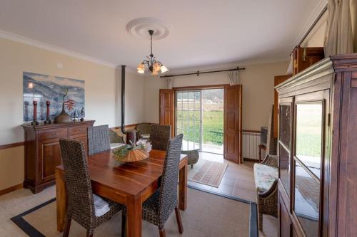 a dining room with a wooden table and chairs at Quinta Sta Luzia Carrascal in Vila Flor