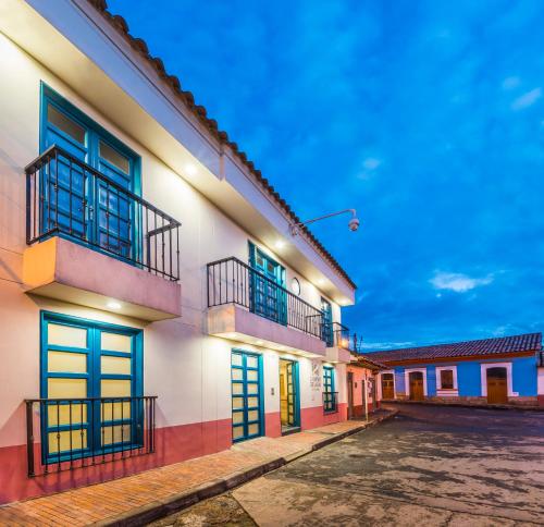 a row of buildings in a street at night at Hotel Camino de la Sal in Zipaquir&aacute;