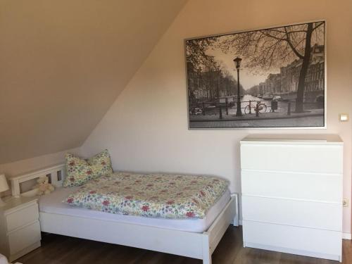 1 dormitorio con 1 cama y una foto en la pared en Ferienwohnung am Dörenberg en Georgsmarienhütte