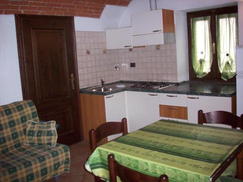 een keuken met een tafel, een tafel en een stoel bij La Ghiacciaia in Verzuolo