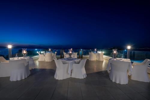 a group of tables and chairs at night at Diamond Deluxe Hotel - Adults Only in Kos Town