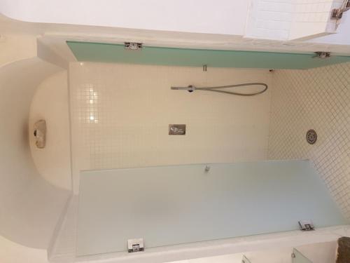 a white bathroom with a clock on the wall at Agenzia Aprea Appartamenti in Ponza