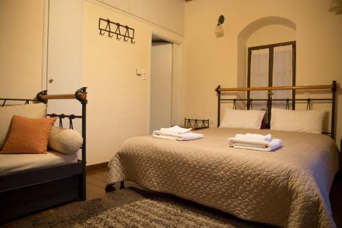 a bedroom with a bed with towels on it at Tholos in Áno Dholianá