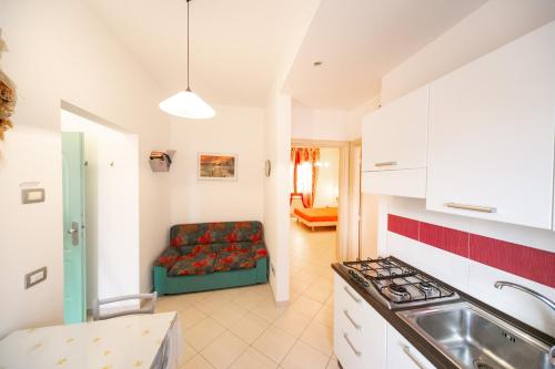 cocina y sala de estar con sofá en Appartamenti Sottomarina Carla, en Sottomarina