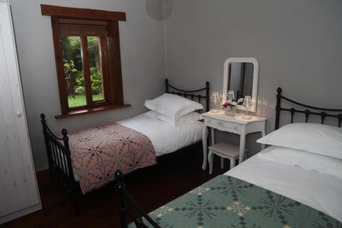 En eller flere senge i et værelse på Ty Carreg Fach Staycation Cottage Cardiff