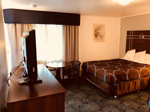 a hotel room with a bed and a flat screen tv at Berkshire Inn in Pittsfield