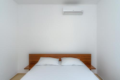 a bedroom with a bed with white sheets at N Apartments in Sutomore