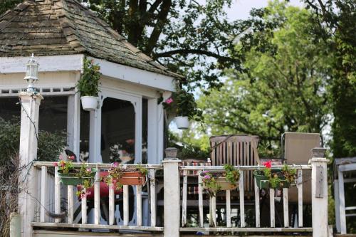 a porch with chairs and flowers on a fence at Aaron's on the Lake in Matlock