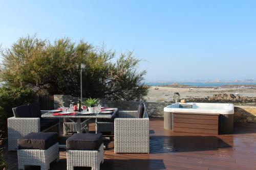 a patio with a table and chairs and a bath tub at Le Prat - Santec in Santec