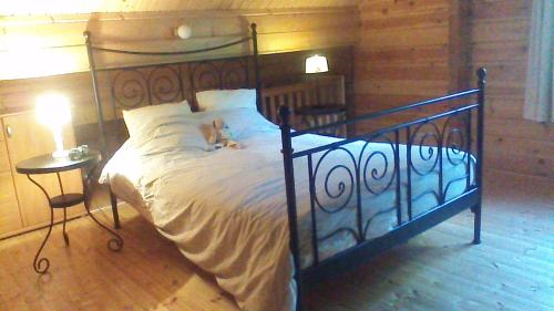 a dog sitting on a bed in a bedroom at Chalet Alppimaja in Vesin