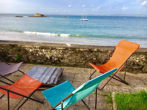 two chairs and a wooden bench next to the ocean at Glaz Ocean in Douarnenez