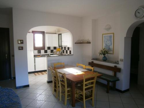 a kitchen and dining room with a table and chairs at Le Canne Apt 1 in San Teodoro