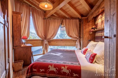 レ・ジェにあるChalet Camomilleの窓のある部屋にベッドがある寝室