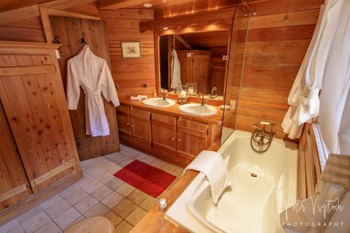 レ・ジェにあるChalet Camomilleの広いバスルーム(シンク2台、バスタブ付)