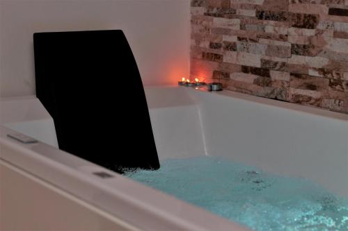 a bath tub filled with water next to a brick wall at B&B Verzavò in Cetraro