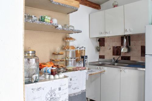 a kitchen with white cabinets and a counter at B&B Verzavò in Cetraro