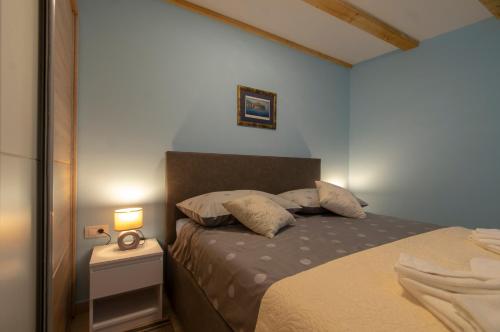 a small bedroom with a bed and a night stand at Apartments Giro Korcula in Korčula