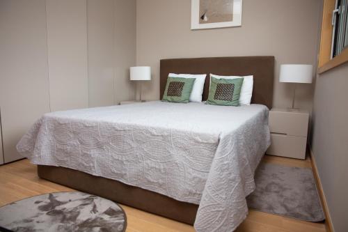 ブラガにあるDesign Flat in Braga - by TonsdeVerdeのベッドルーム(緑の枕が付く大きな白いベッド付)