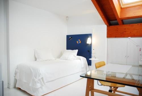 a bedroom with a white bed and a glass table at Super Luxury Penthouse in Jávea