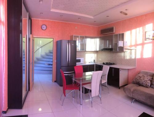 a kitchen and dining room with a table and chairs at Тownhouse99 in Petropavlovskaya Borshchagovka