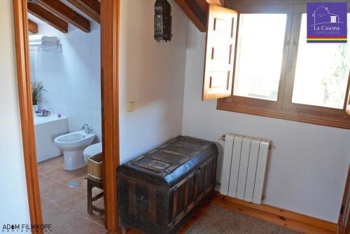 a small bathroom with a toilet and a window at La Casona de Castilnovo - Gay Men Only in Valdesaz