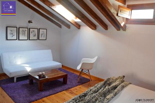 a living room with a white couch and a table at La Casona de Castilnovo - Gay Men Only in Valdesaz
