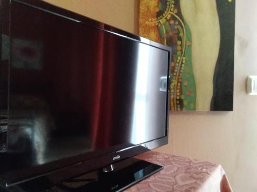 TV de pantalla plana en la parte superior de una mesa en B&B "Al Calopinace" en Reggio Calabria