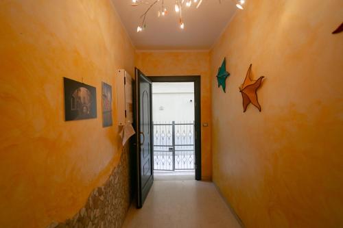 a hallway with an orange wall and a door at Appartamenti Sottomarina Carla in Sottomarina