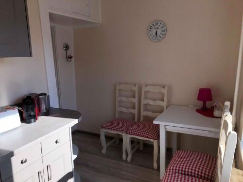 a kitchen with a table and chairs and a clock on the wall at Las Palomas in Ventspils