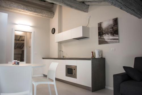 a white kitchen with a counter and a table at Residenza La Torre in Mantova