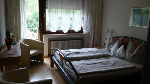 a bedroom with two beds in front of a window at Gästehaus Schneider in Brauneberg