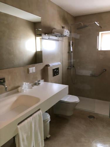 a bathroom with a sink and a toilet and a shower at Hotel Paiva in Monte Gordo