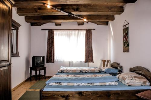 a bedroom with two beds and a window at MotoCamp Cisnadioara - only for bikers! in Cisnădioara