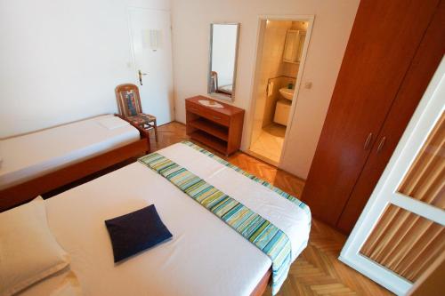 a small room with a bed and a mirror at Villa Volga in Jelsa