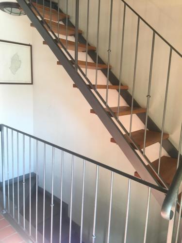 a staircase in a building with metal railing at Casa del porticciolo di Capraia in Capraia