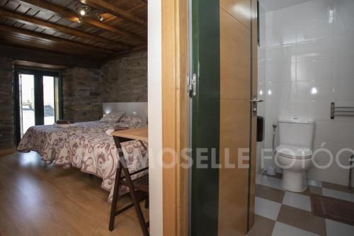 a bedroom with a bed and a toilet in a room at Pension Siete en el Camino in Sarria