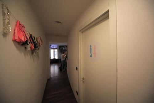 a hallway with a door and a person walking down it at Dopa Hostel in Bologna