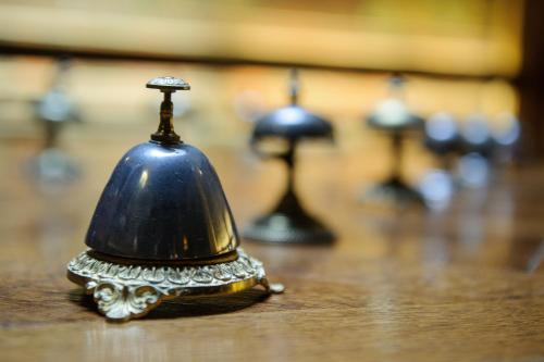 a bell on top of a wooden table at Hôtel Les Chevaliers in Laon