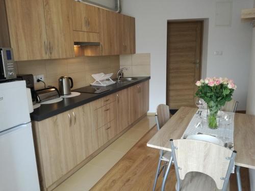 a kitchen with a table with a vase of flowers at Apartamenty INTERDOM in Zakopane