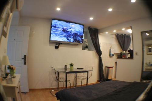 a bedroom with a tv on the wall and a table at Amorino Apartman Studio in Opatija