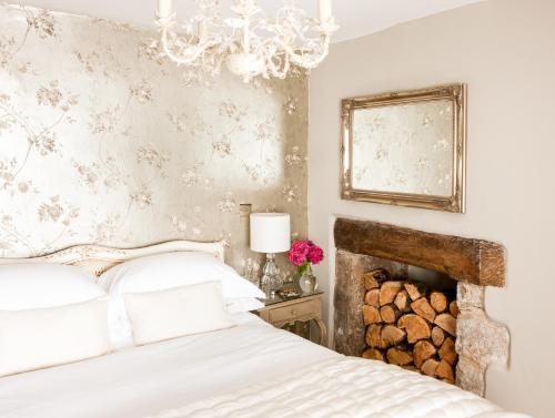 a bedroom with a white bed and a chandelier at Moorland View Cottage in North Bovey