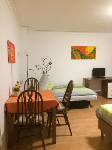 ein Esszimmer mit einem Tisch, Stühlen und einem Bett in der Unterkunft Abels Appartements in Bochum