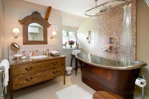 a large bathroom with a tub and a sink at Moorland View Cottage in North Bovey