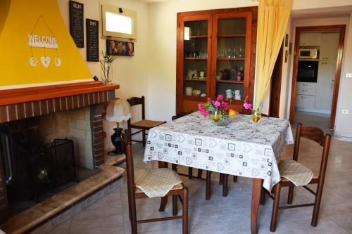 een eetkamer met een tafel en een open haard bij Chez Pierre in Santa Maria Navarrese