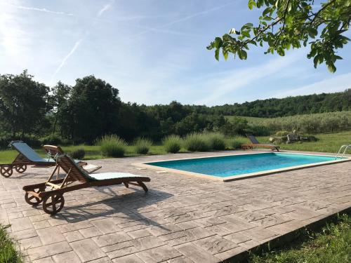 a patio with a swimming pool and two lounge chairs at Villa Bellevue in Vižinada