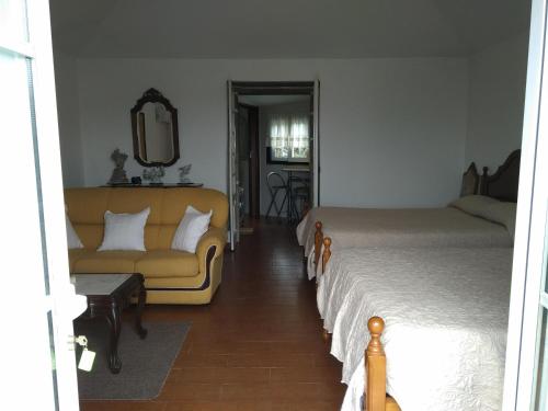 a bedroom with a bed and a couch and a mirror at Residencial Retiro Sra. da Luz in Ponte de Lima