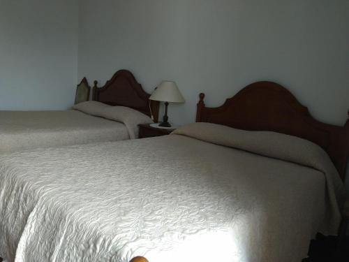 a bedroom with two beds and a lamp on a table at Residencial Retiro Sra. da Luz in Ponte de Lima