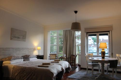 une chambre d'hôtel avec deux lits, une table et des chaises dans l'établissement AL embaixador, à Alenquer