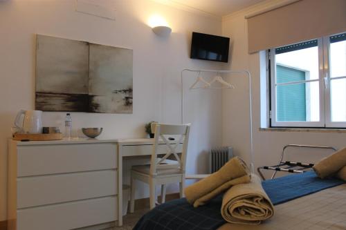 a bedroom with a desk and a bed with a chair at AL embaixador in Alenquer