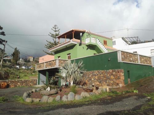 una casa verde y blanca con una escalera. en Casa Fagundo en Puntagorda